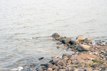 big rocks in the dark water of the bay on a cold cloudy day