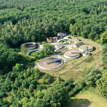 Aerial View Of A Wastewater Treatment Plant With Clarifier, Aeration Basin, Sedimentation Basin, And Secondary Clarifier In An Agricultural Setting.