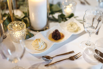 Butter and bread spreads on a small white tray at a wedding 