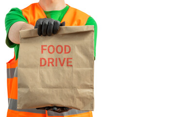 Food Distribution. Volunteer carrying food donation box. A young smiling man wearing green uniform...