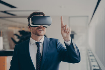 Smiling bearded businessman in 3d goggles using augmented reality in work