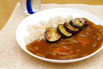チキンスープで炊いたライスを使ったカレーライスに焼きナスをトッピング