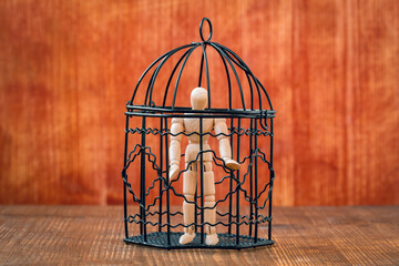 Fototapeta na wymiar Wooden mannequin inside a birdcage
