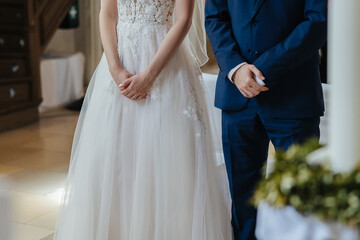 Bride and groom standing next to each other, hands close-up
