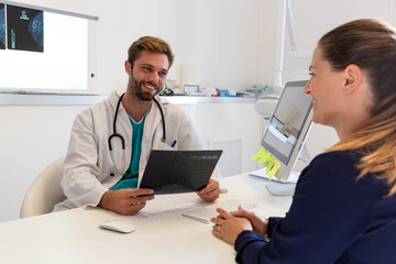 Obraz premium doctor with smile gives the results of an x-ray to his patient