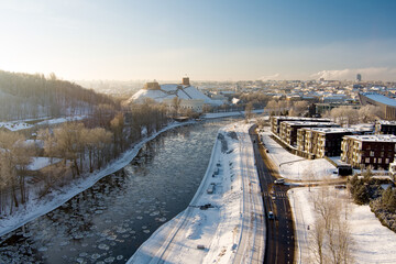 Naklejka premium Beautiful Vilnius city panorama in winter with snow covered houses, churches and streets. Aerial evening view. Winter city scenery in Lithuania.