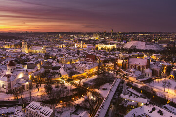 Fototapeta na wymiar Beautiful Vilnius city panorama in winter with snow covered houses, churches and streets. Aerial evening view. Winter city scenery in Lithuania.