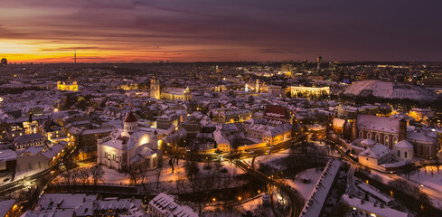 Beautiful Vilnius city panorama in winter with snow covered houses, churches and streets. Aerial evening view. Winter city scenery in Lithuania.