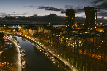 Aerial view of cityscape of Klaipeda at night. Yachts and boats docked along the embarkment of Dane...