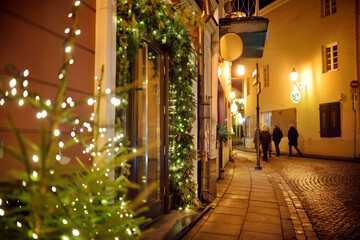 Narrow streets of Vilnius Old Town decorated for Christmas. Christmas lights, trees and ornaments...