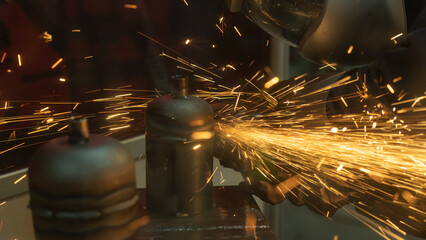 Worker grinding and polishing metal part with sparks indoor workshop, close-up.