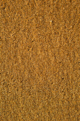 Background with golden sand on the coast of the island of Crete. Abstract surface with sand and clear sea water for text.