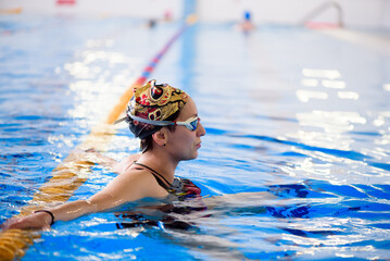 Swimming workout in the sports pool. The coach shows a swimming master class.