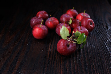 Red apples with water drops on the peel on a wooden table.