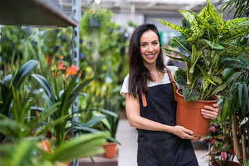 Shot of a young woman working with plants in a garden centre