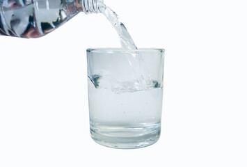 Pouring water into a glass on a white background