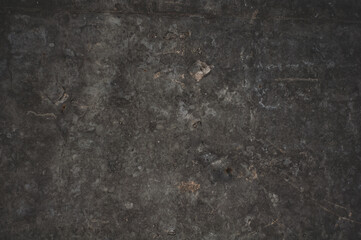 Darkened concrete surface with stains and scuffs, grungy vintage background close-up, grunge texture.