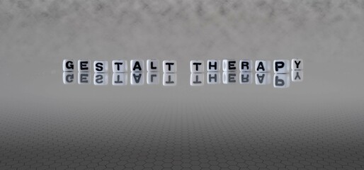 gestalt therapy word or concept represented by black and white letter cubes on a grey horizon...