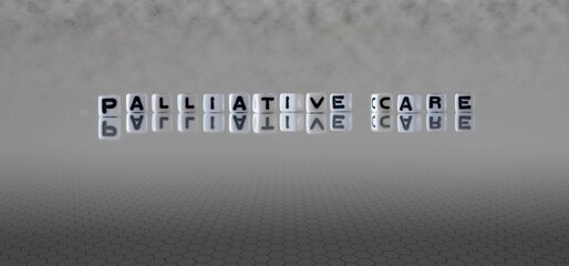 palliative care word or concept represented by black and white letter cubes on a grey horizon...
