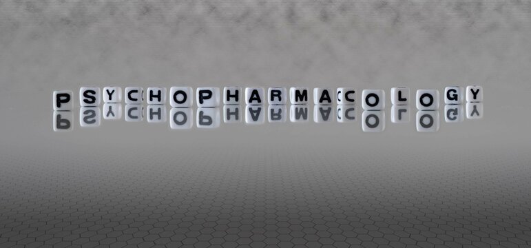 psychopharmacology word or concept represented by black and white letter cubes on a grey horizon background stretching to infinity