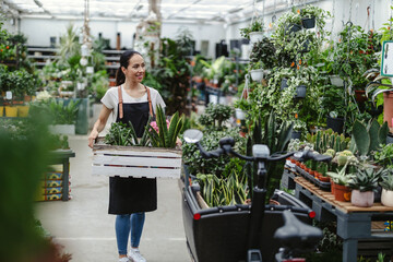 Shot of a young woman working with plants in a garden centre