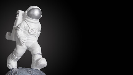 Plastic toy figure astronaut on a dark background with copy space. World Space Week 2022. Space and...