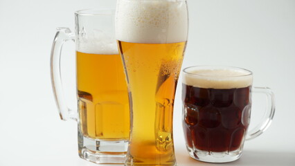 Three mugs of beer different flavor - light, dark, and red