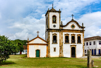 Fototapeta na wymiar Old historic church surrounded by colonial houses in the famous and bucolic city of Paraty on the coast of Rio de Janeiro