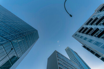 Fototapeta na wymiar Looking up at modern houses buildings and street light pole against blue sky