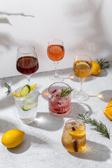 Sparkling holiday punch and various drinks. Glasses of sparkling punch on light background. Cocktail with orange, Ice and cinnamon. Refreshing Summer Drink.Free space for your text