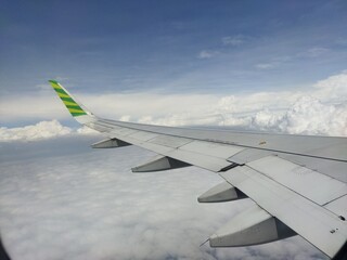 Fototapeta premium view of the clouds san airplane wing from above the clouds