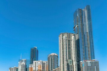 Fototapeta na wymiar Towering modern luxury apartments against blue sky background on a sunny day