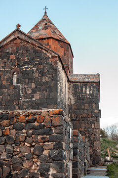 Close-up of the Christian stone temple in Sevanavank Armenia in the sunset sunlight. The walls of the temple are made of stone. Ancient historical and cultural monument of Armenia
