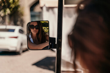 A middle-aged woman is driving a car for transporting tourists. Electric car, Tourist bus. Car for transporting people around the hotel, park, golf club