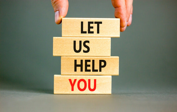 Support and let us help you symbol. Concept words Let us help you on wooden blocks on a beautiful grey table grey background. Businessman hand. Business, support and let us help you concept.