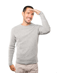 Happy young man with a gesture of looking away