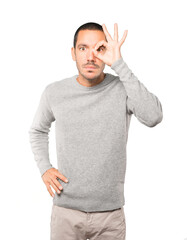 Amazed young man using his hands like a binoculars