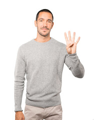 Young man making a number four gesture