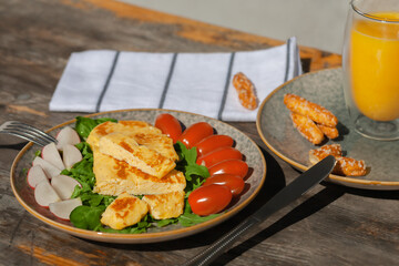 A light breakfast of French omelet with radishes, spinach tomatoes and arugula. European Breakfast