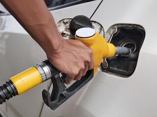 Man Handle pumping gasoline fuel nozzle to refuel. Vehicle fueling facility at petrol station....