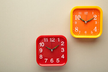 Yellow and red wall clock on grey background.
