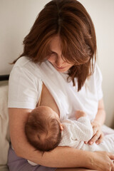 Obraz na płótnie Canvas Mother breastfeeding her newborn baby boy. Realistic home portrait