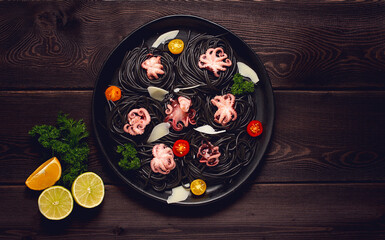 Mini octopuses, with black pasta, spaghetti, on a black plate, top view, horizontal, no people, homemade,
