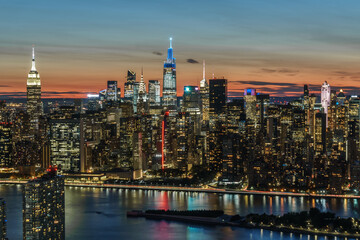 Fototapeta premium Aerial view of New York city, Empire State Building, Chrysler Building, One Vanderbilt, 30 Rock at sunset and twilight