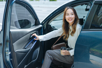 Asian business woman gets out of car and holding phone and coffee cup, right-hand drive, left-hand traffic, business lady, white business class luxury