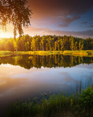 Splendid view of a calm lake and green forests on a sunny day.