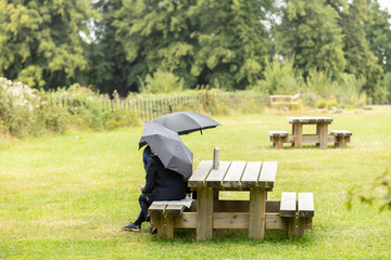A couple on the bench under umbrella, british summertime concept