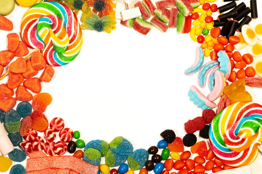 white background with sweets, jelly beans, marshmallows, marshmallows, clouds, candies, hearts, making a circle and leaving a space for the text.
