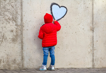 Obraz na płótnie Canvas Street artist child painting heart symbol wall world love concept