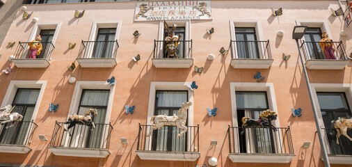 Carrousel at every windows on an orange building